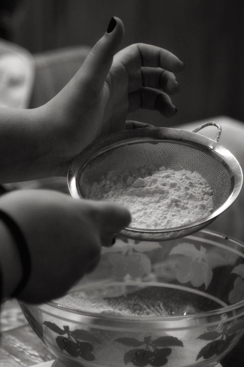 Sifting flour into a mixing bowl